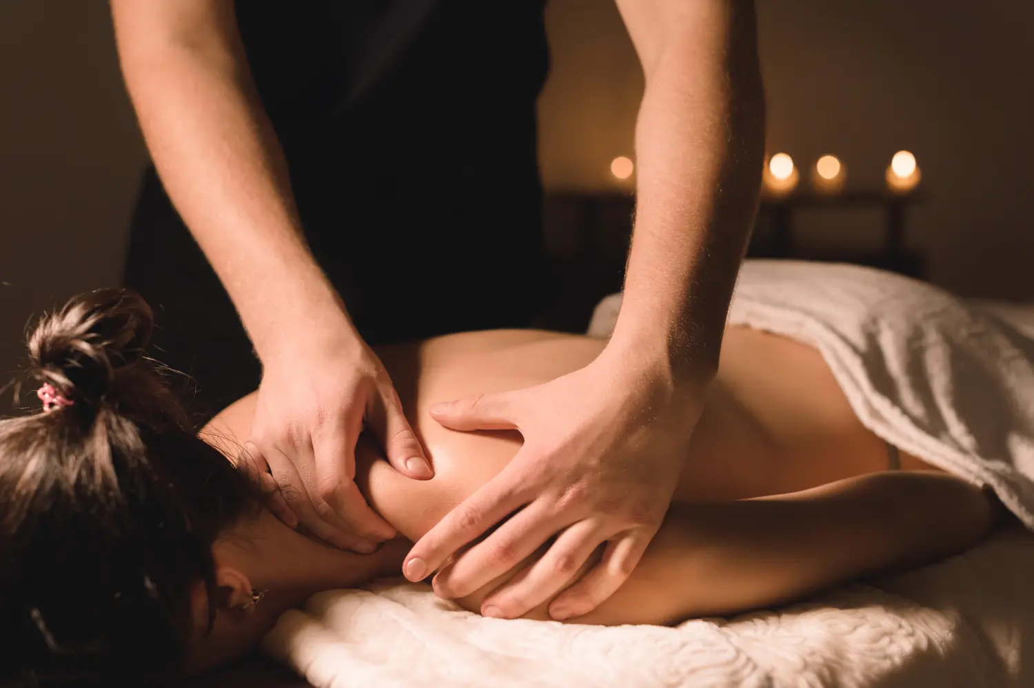 Männliche Arbeiter Spa-Massage zu tun, um ein junges Mädchen in einem dunklen Raum hautnah vom Wellnesszentrum Unterhaching